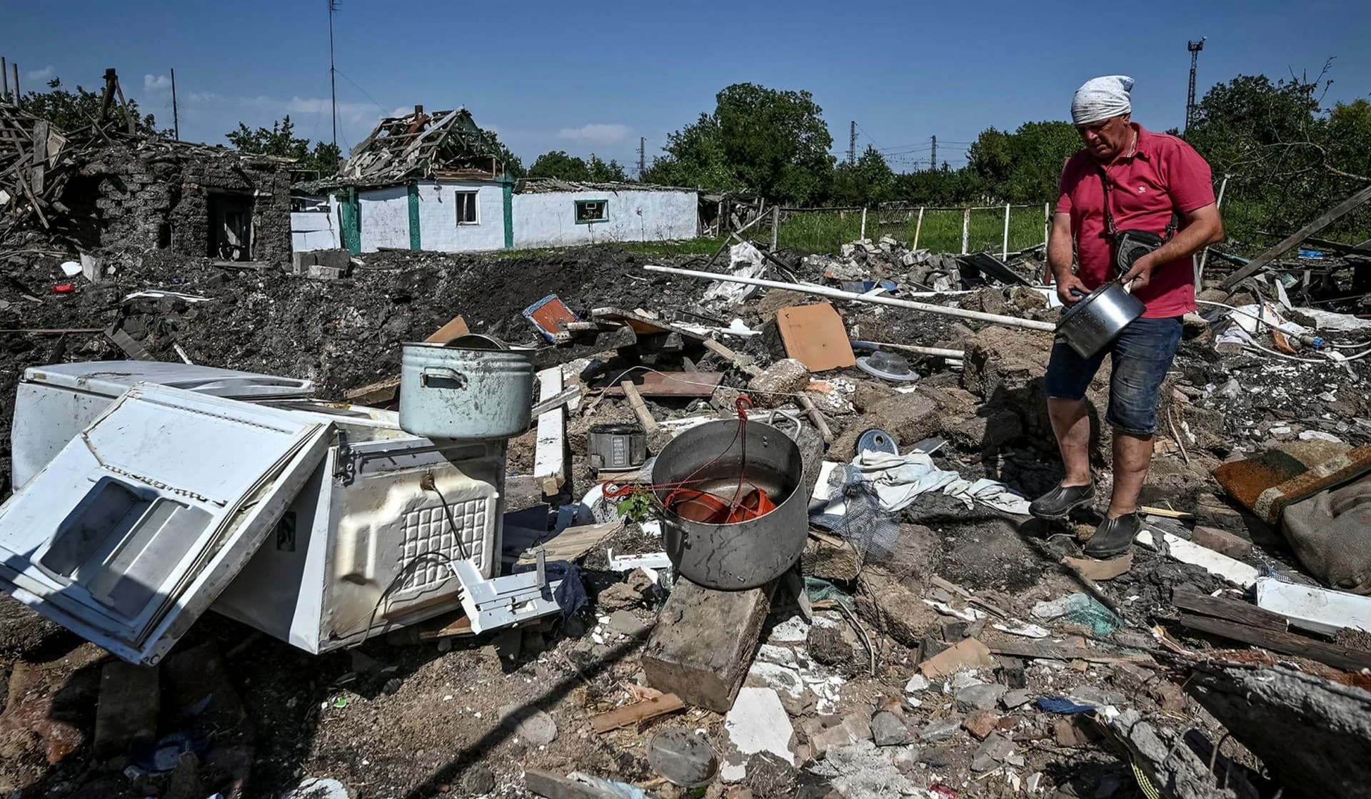 A local resident collects items around his house destroyed by yesterday's Russian military strike in Chaplyne