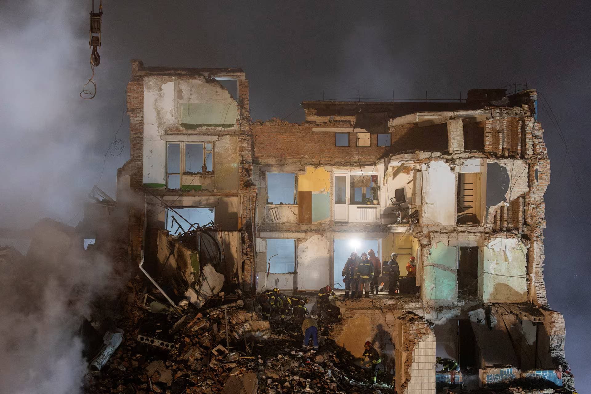 Rescuers clear debris at the site of an apartment building that was hit yesterday by a Russian missile in Ternopil