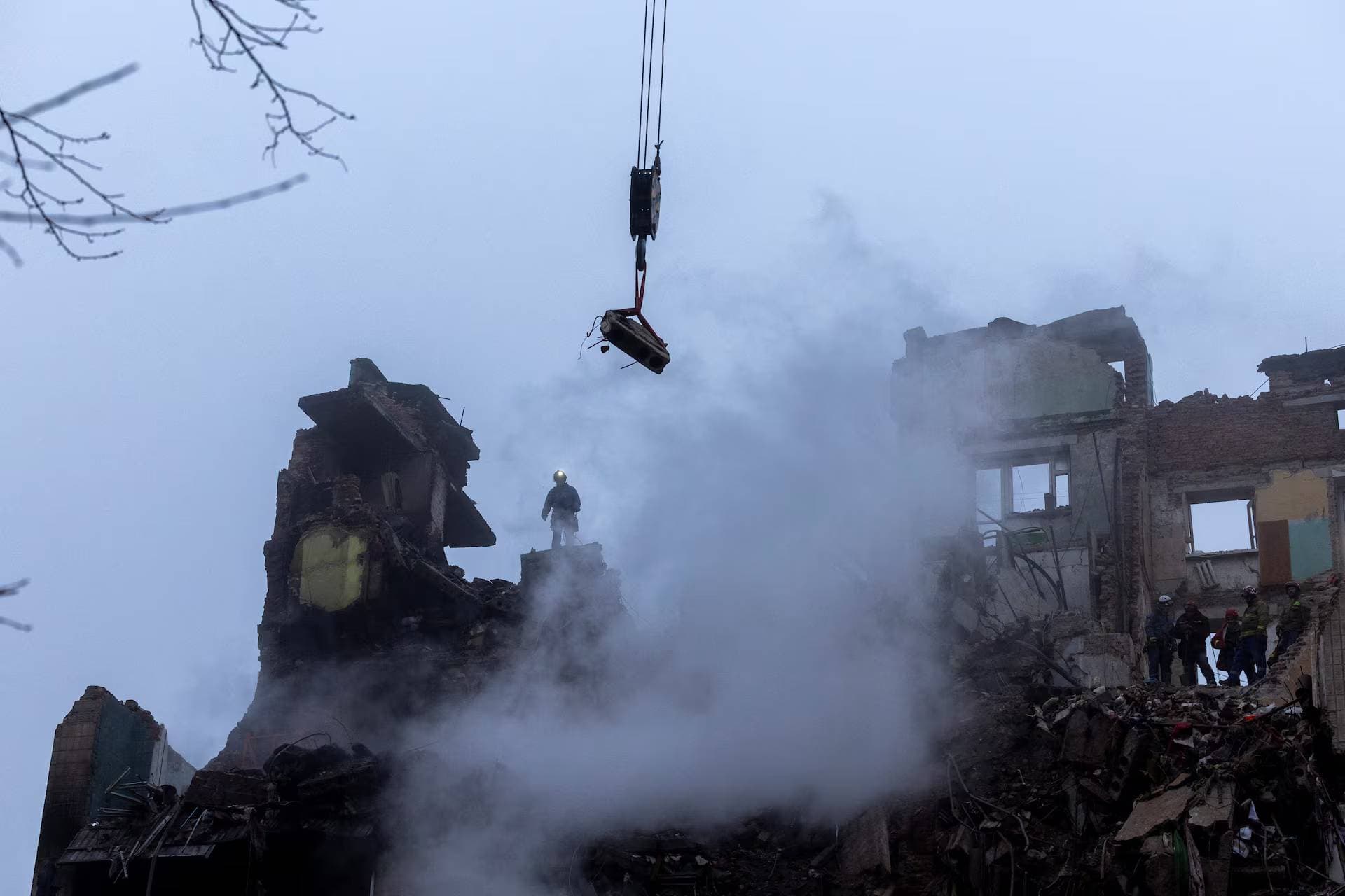 Rescuers clear debris at the site of an apartment building that was hit yesterday by a Russian missile in Ternopil