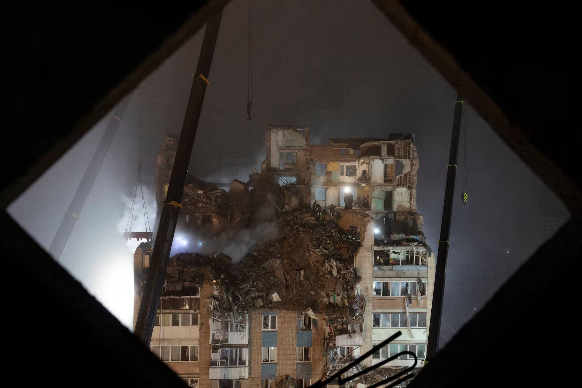 Rescuers clear debris at the site of an apartment building that was hit yesterday by a Russian missile in Ternopil