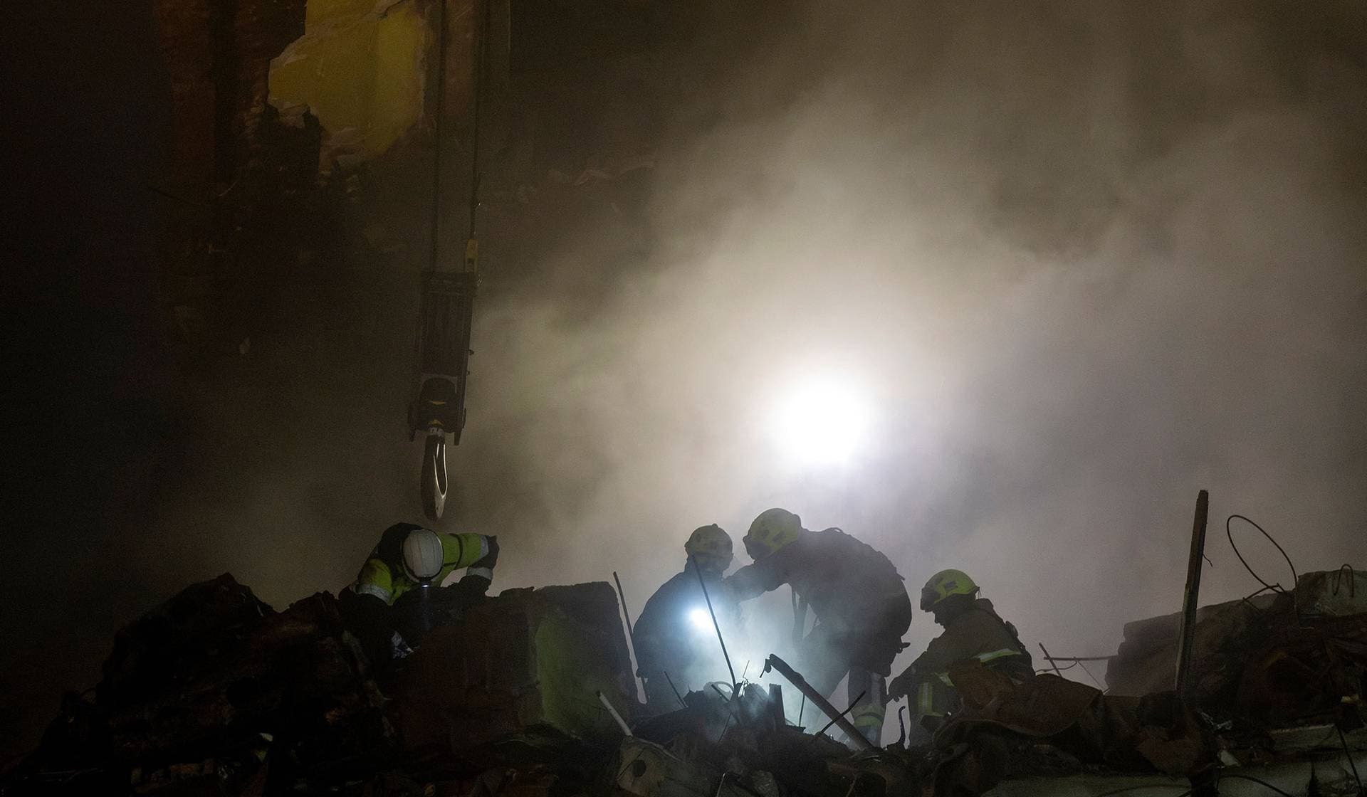 Emergency responders dig through the rubble of a partially collapsed apartment building hit yesterday by a Russian missile in Ternopil