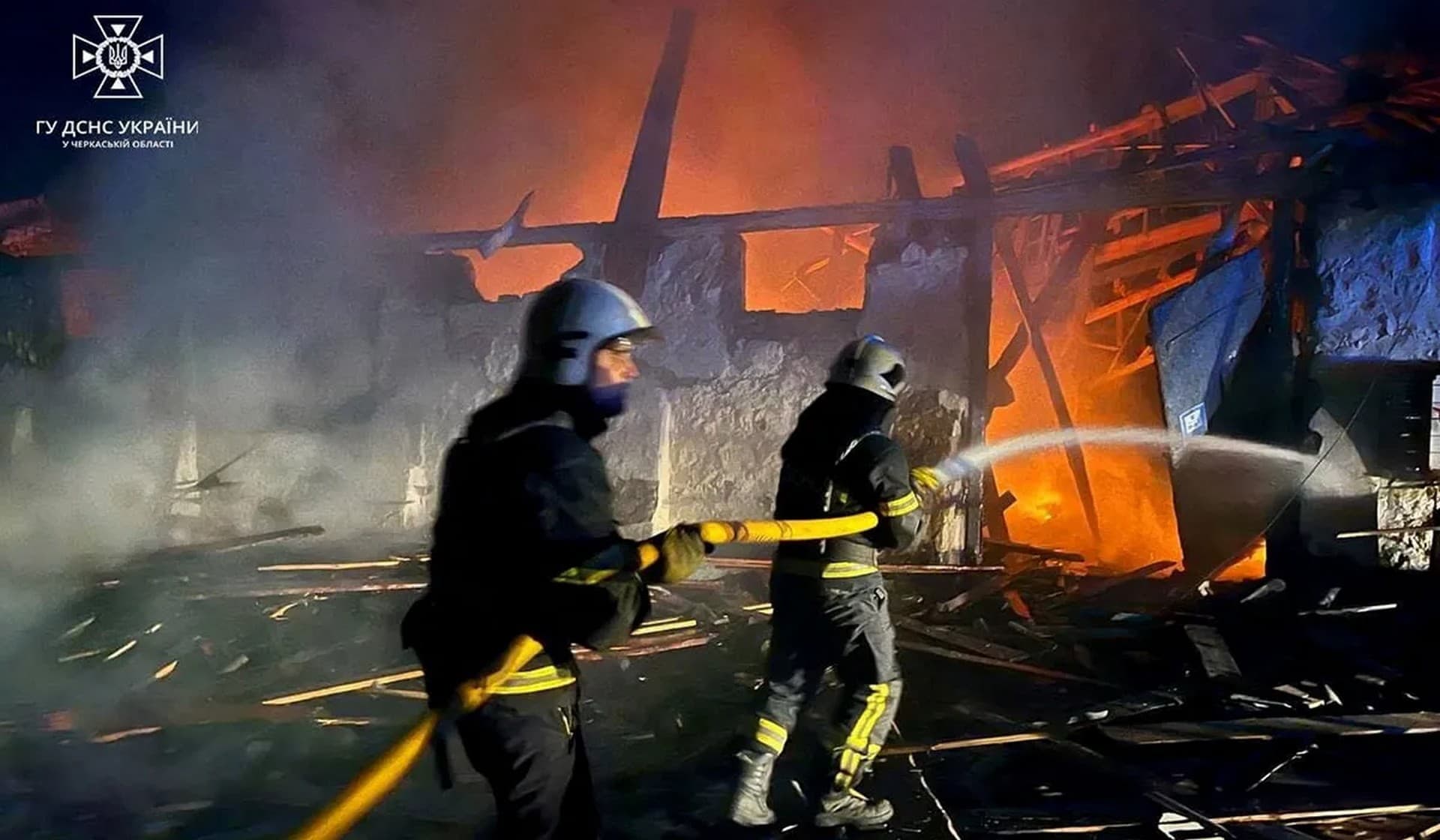 Firefighters work at a site of grain warehouses hit during a Russian drone strike in Uman