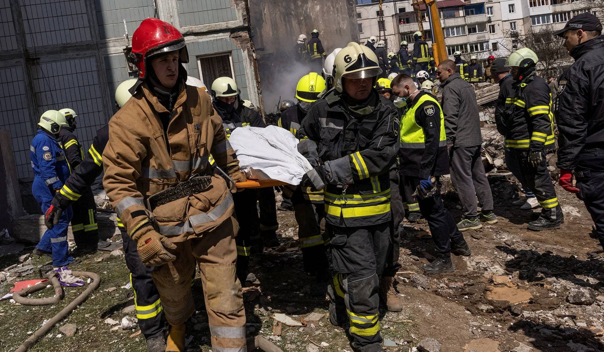 Rescuers carry a covered body as they work at the site of a heavily damaged residential building hit by a Russian missile in Uman, Cherkasy Region, Ukraine, April 28, 2023.