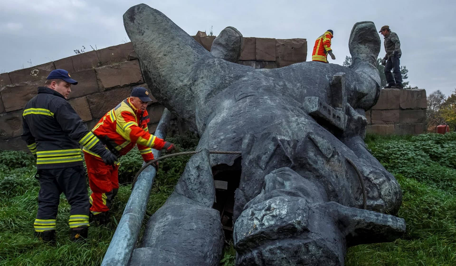 Members of the State Emergency Service inspect a dismantled monument dedicated to Soviet liberators following a decision by local authorities in Uzhhorod