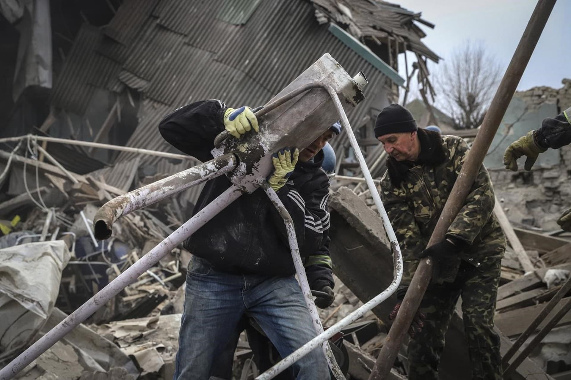 Ukrainian volunteers clear debris at a damaged maternity hospital in Vilniansk