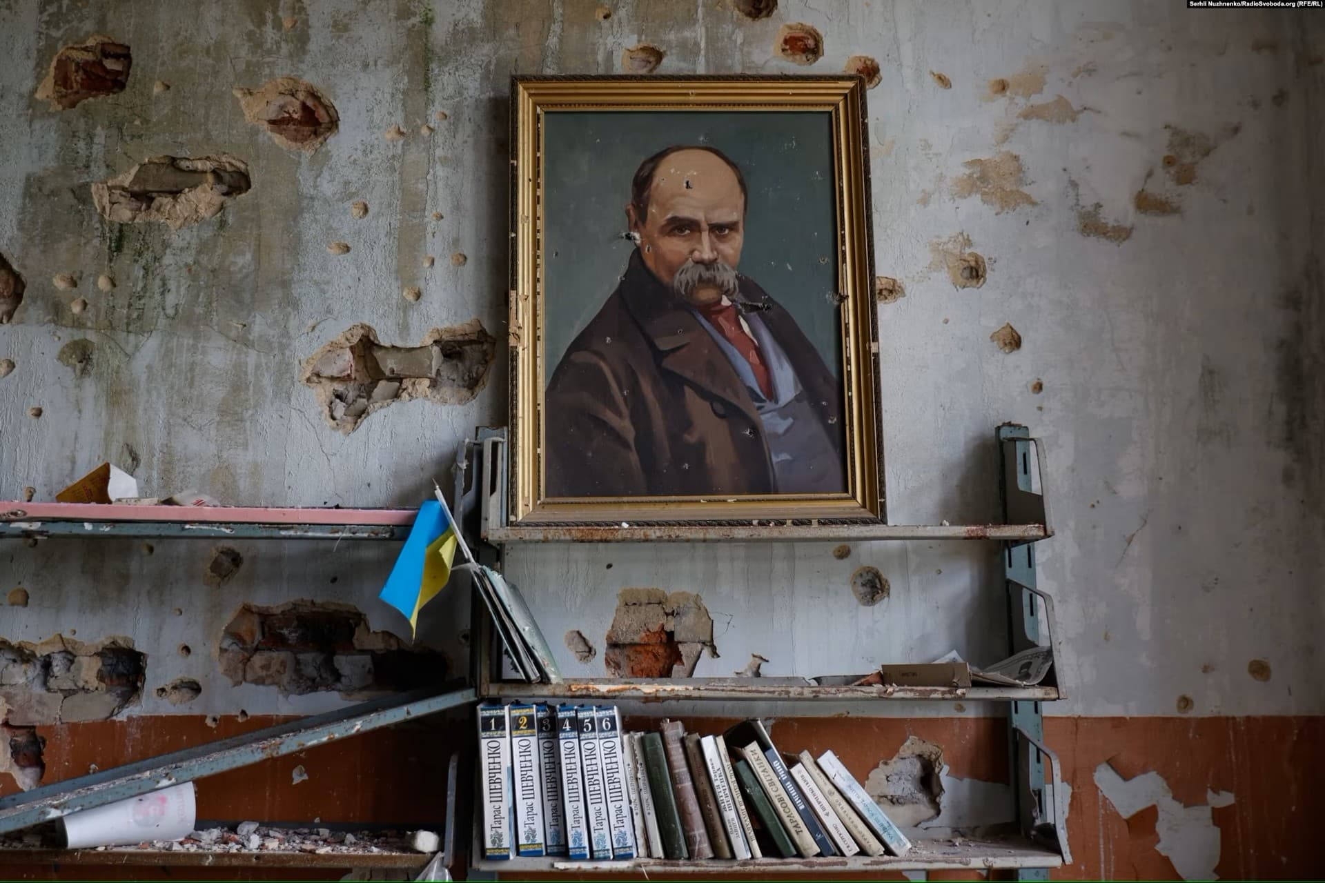 A framed painting of the Ukrainian poet Taras Shevchenko is surrounded by bullet holes in the library of Blahodatne's House of Culture