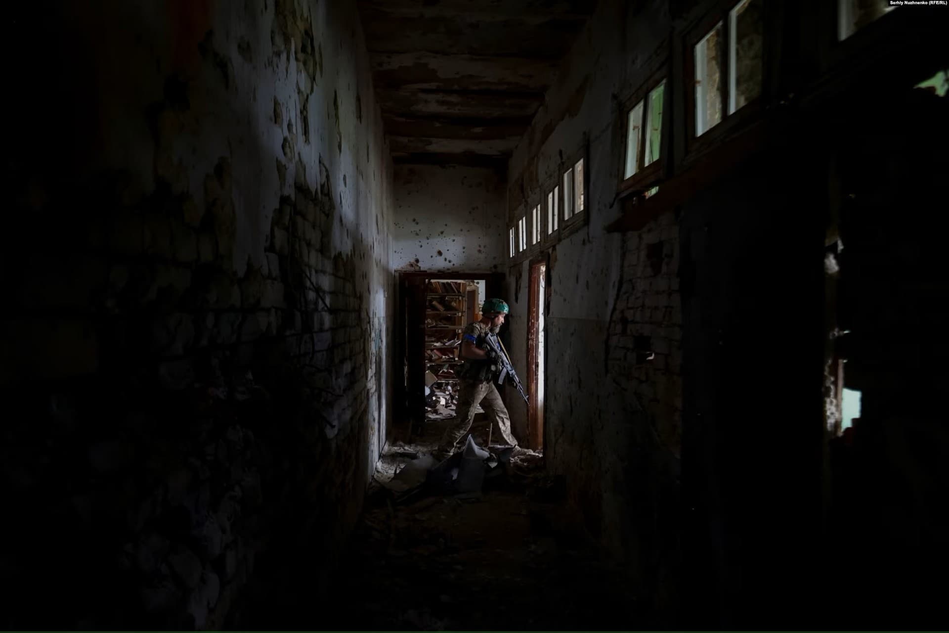 A Ukrainian soldier walks through Blahodatne's House of Culture