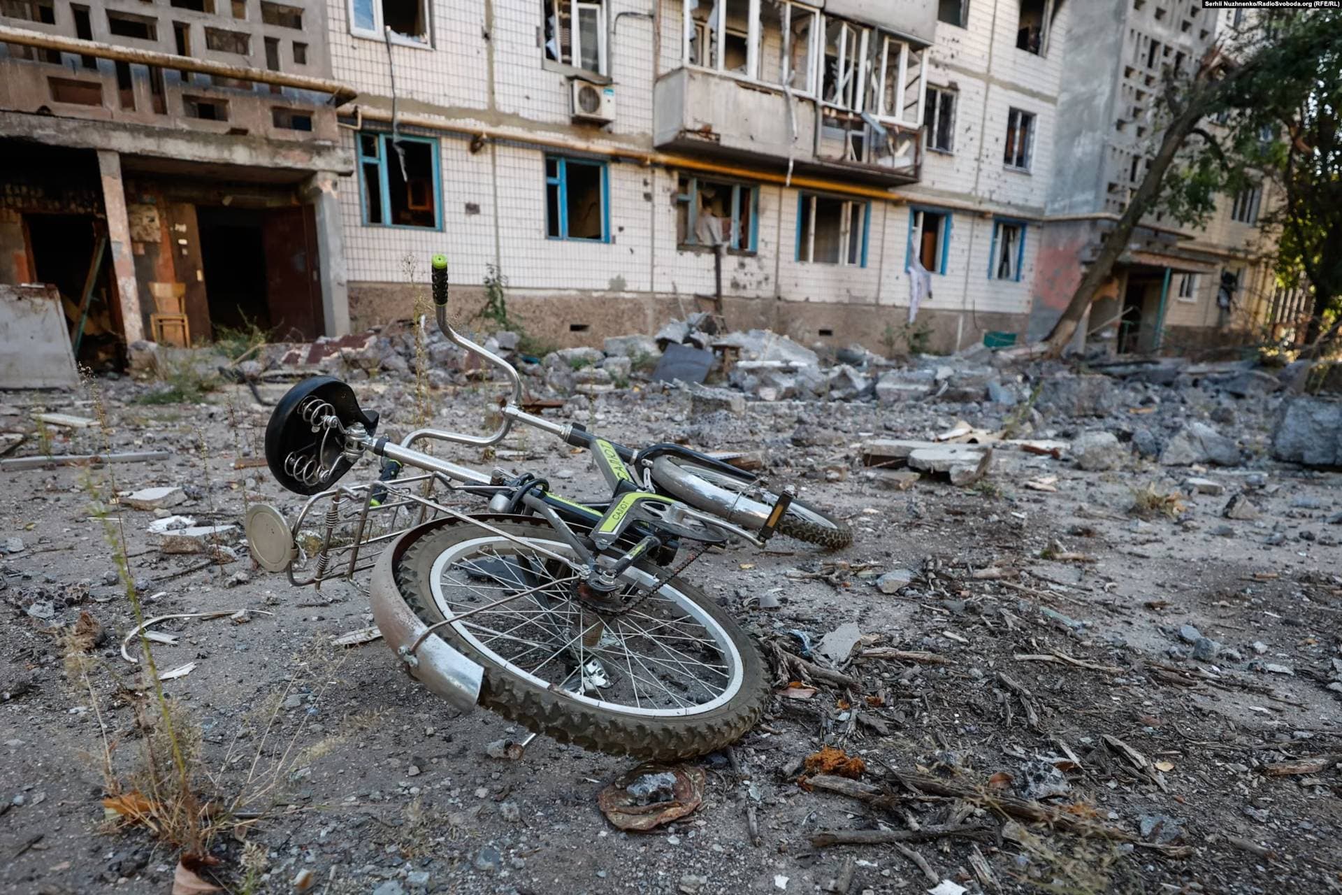 A child's bike in a rubble-strewn courtyard