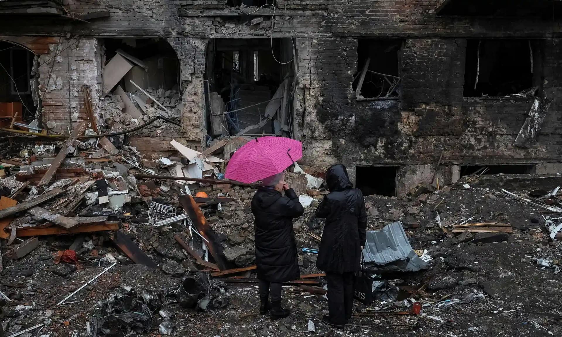 Residents look over the remains of their building, which was destroyed by a Russian missile on Wednesday, in the Kyiv suburb of Vyshhorod.
