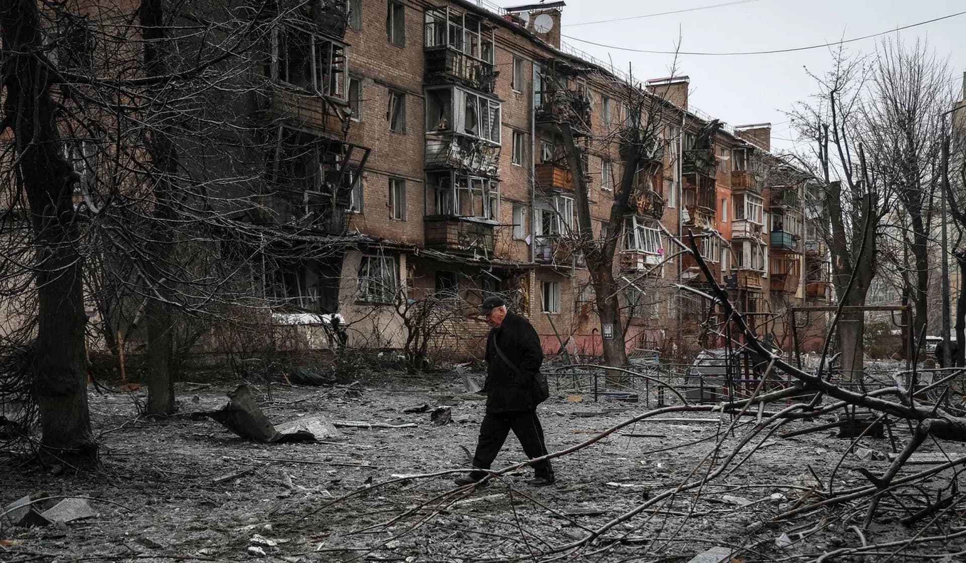 A local resident walks near a residential building destroyed by a Russian missile attack in the town of Vyshhorod
