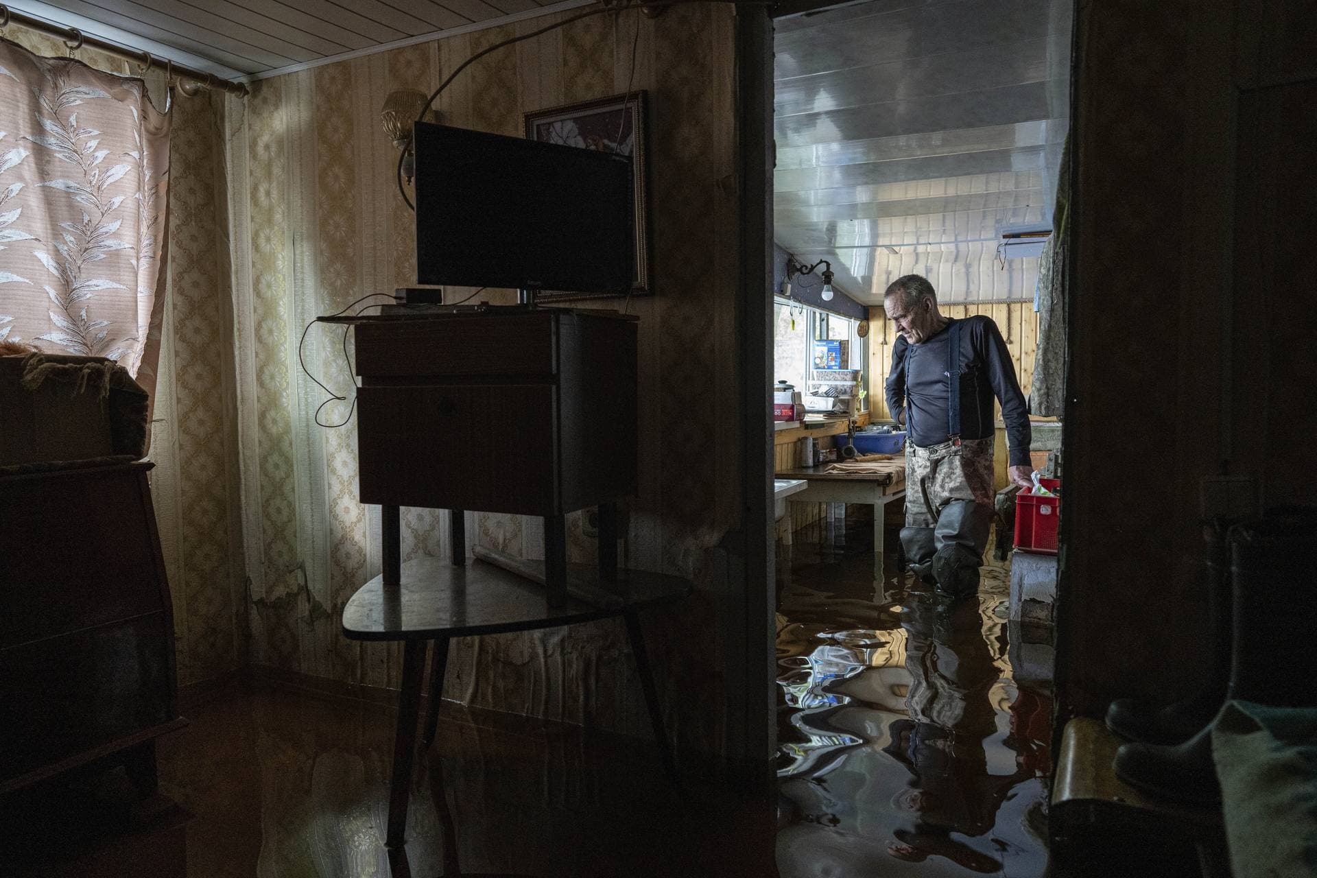Ihor Medyunov stands at the kitchen of his flooded house in the island of Kakhovka reservoir on Dnipro river near Lysohirka