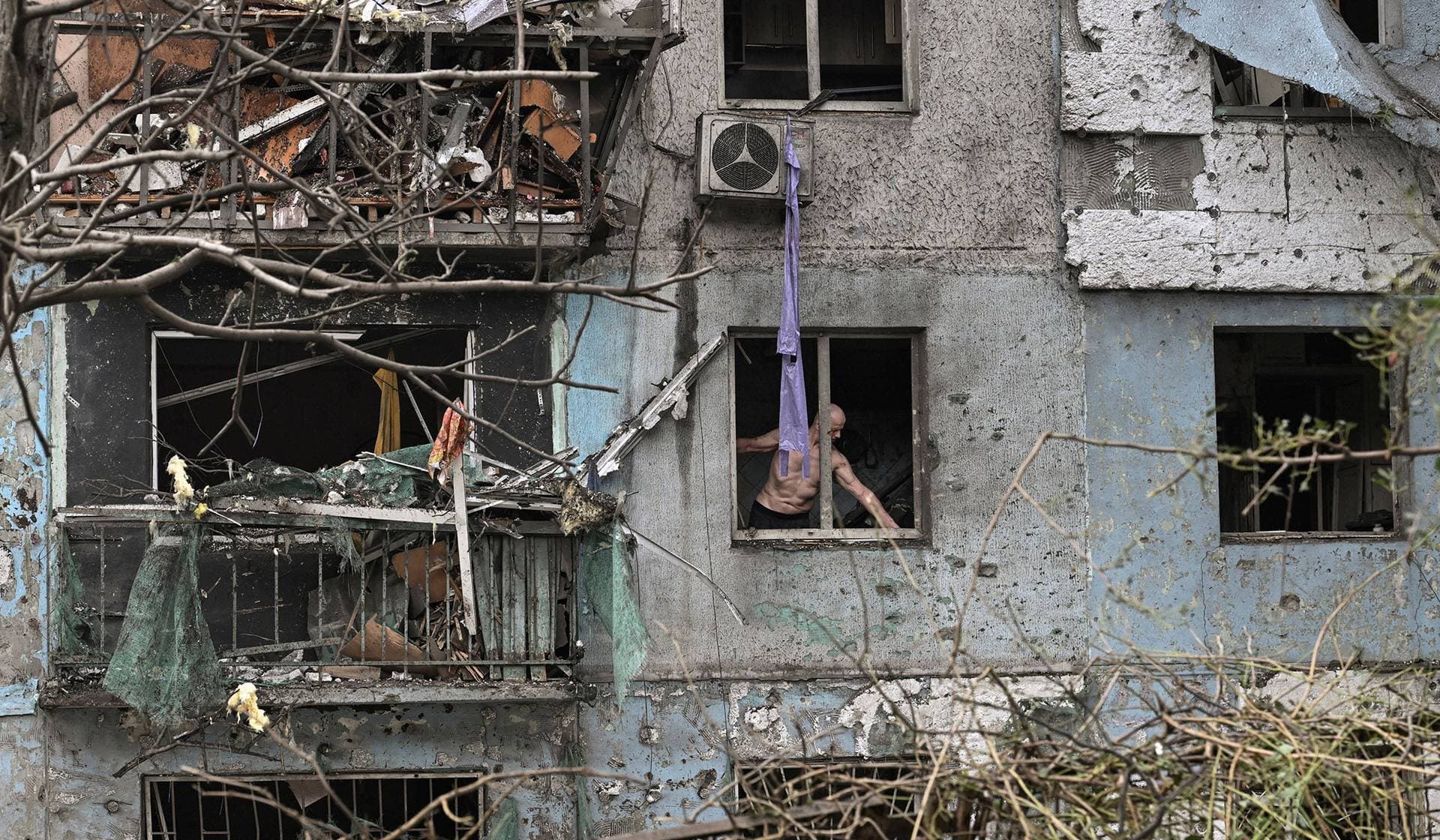 A resident removes debris from his apartment damaged by a Russian air strike in Zaporizhzhia