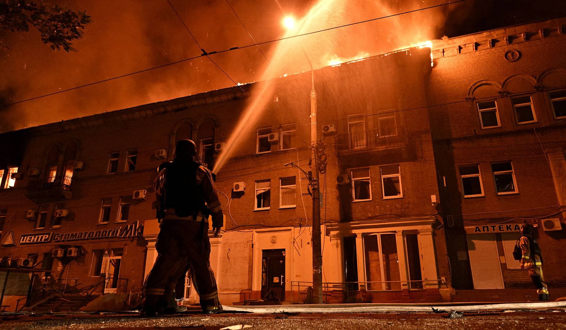 Firefighters work at a site of an apartment building hit by a Russian drone strike in Zaporizhzhia