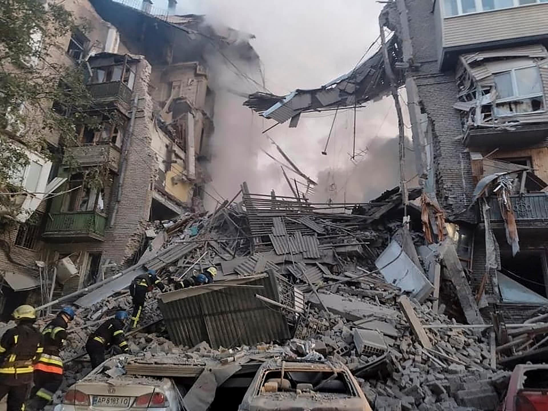 rescuers work on a scene of building damaged by shelling in Zaporizhzhia