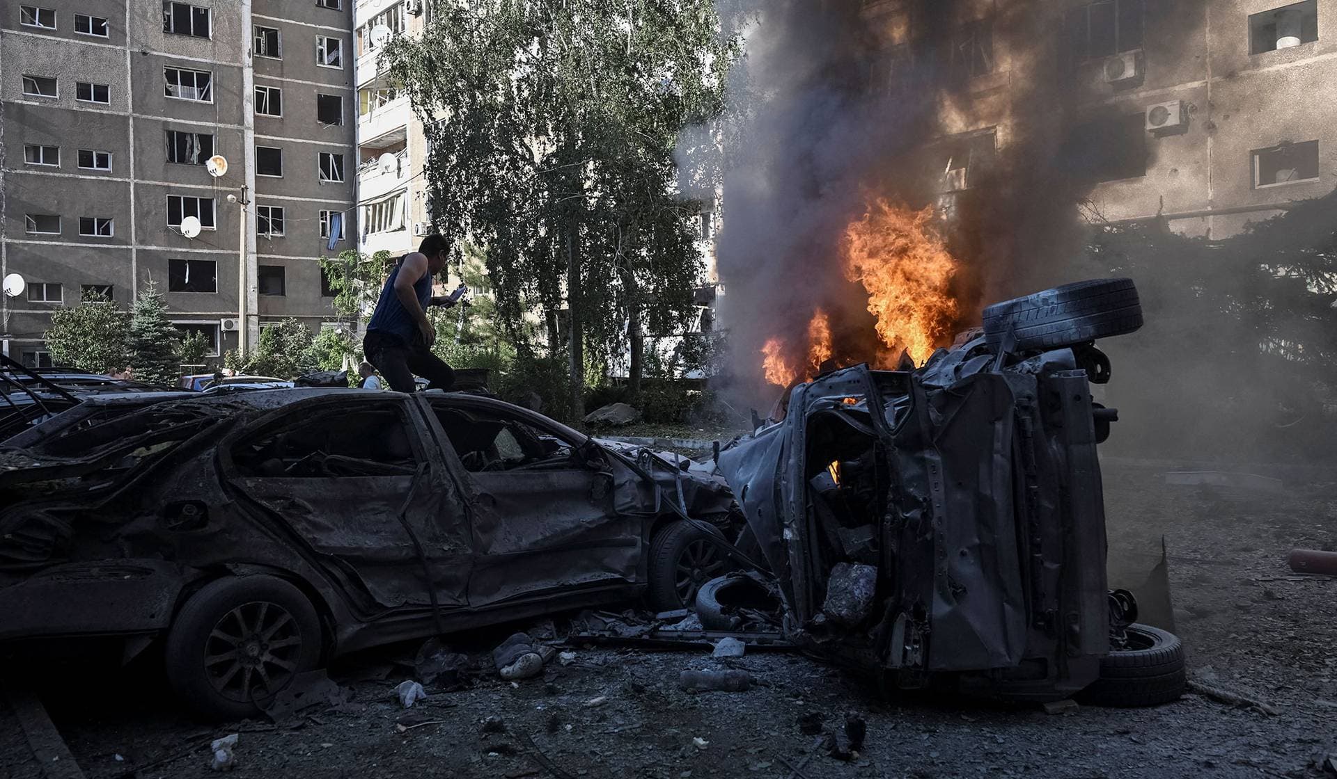 Cars burn near apartment buildings at the site of a Russian air strike in Zaporizhzhia