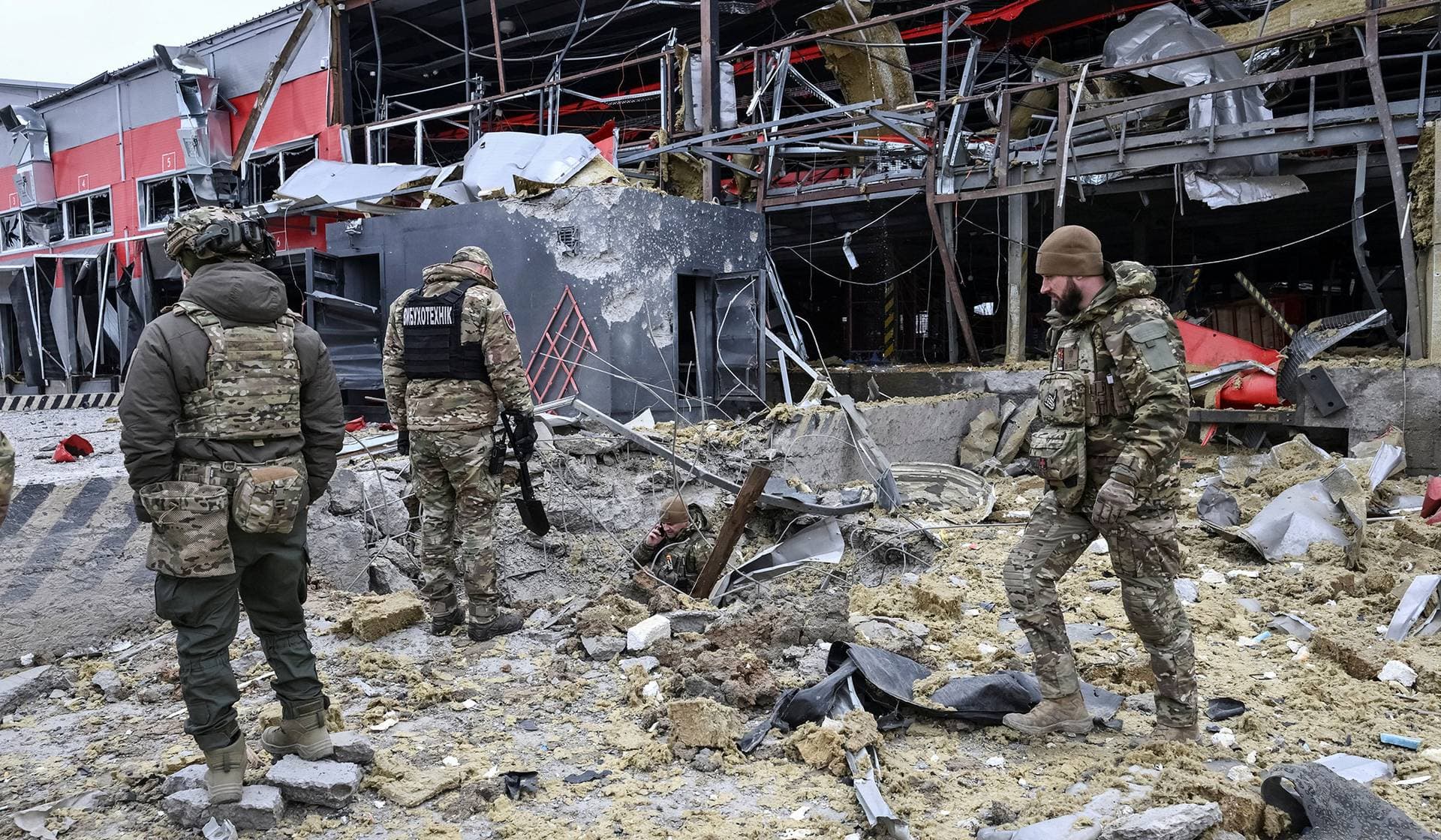Police bomb squad members work at a site of a postal distribution centre of Nova Post company hit by Russian missile in Zaporizhzhia