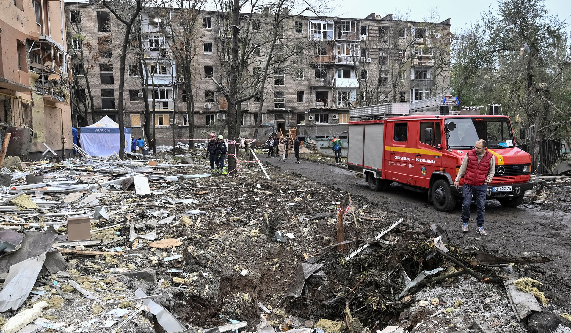 A resident looks at a crater that appeared at the site of an apartment building damaged during a Russian air strike in Zaporizhzhia