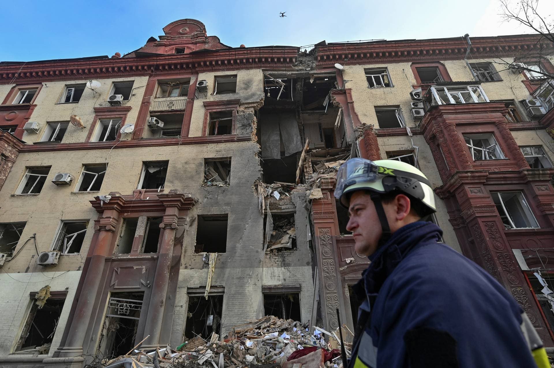 A rescue personnel stands in front of a residential building damaged by a Russian missile strike in Zaporizhzhia
