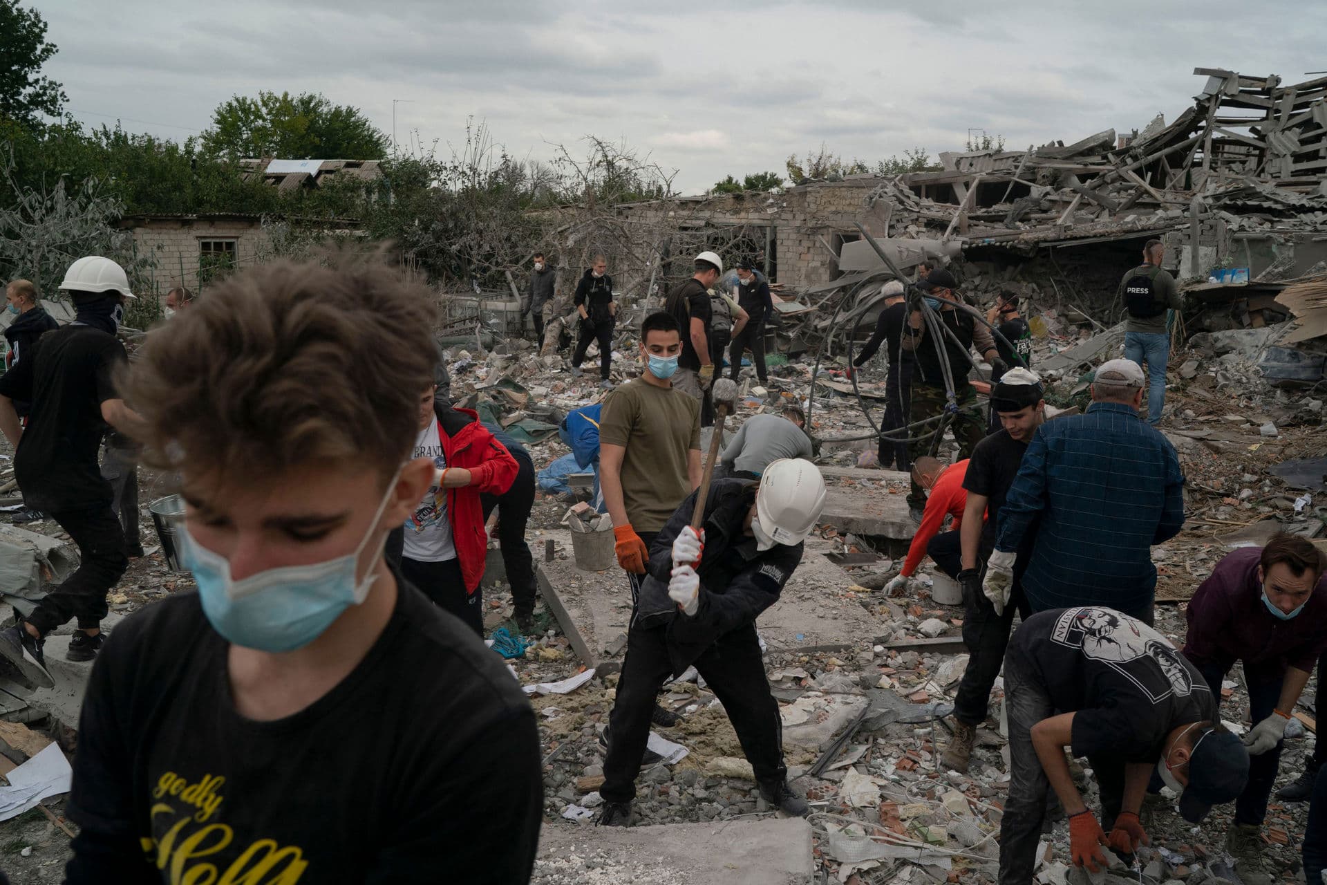 Volunteers work to clean the debris on a site where several houses were destroyed after a Russian attack at a residential area in Zaporizhzhia