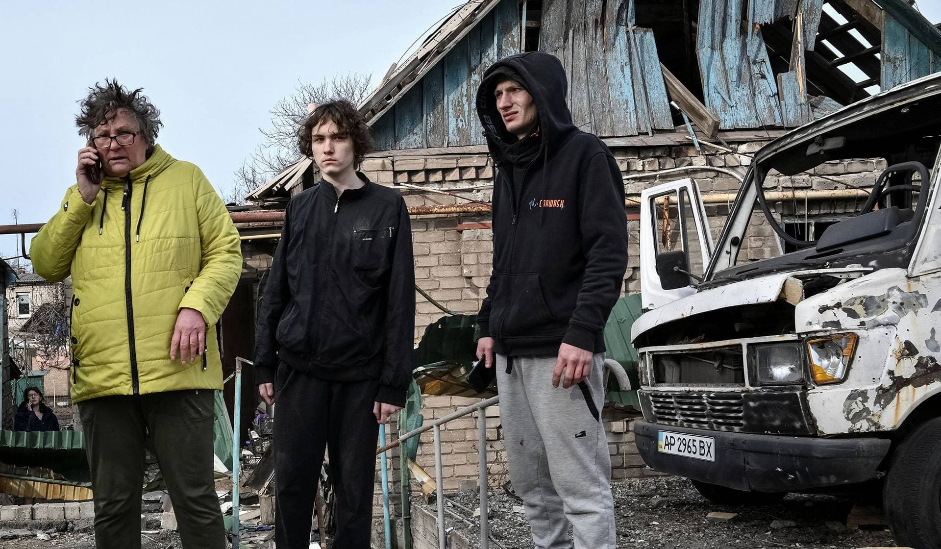 Residents stand near their building hit by a Russian drone strike in Zaporizhzhia