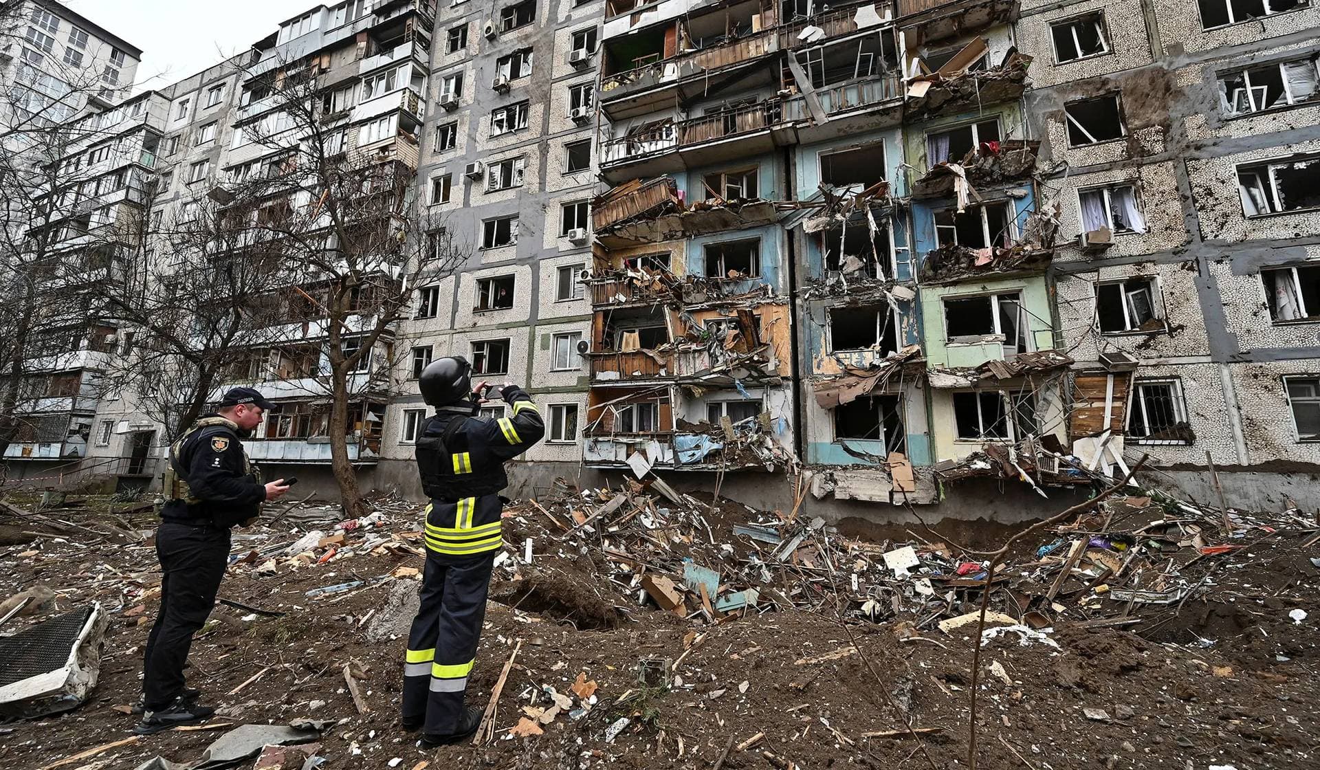A rescue team member takes a picture of an apartment building damaged during a Russian missile strike in Zaporizhzhia