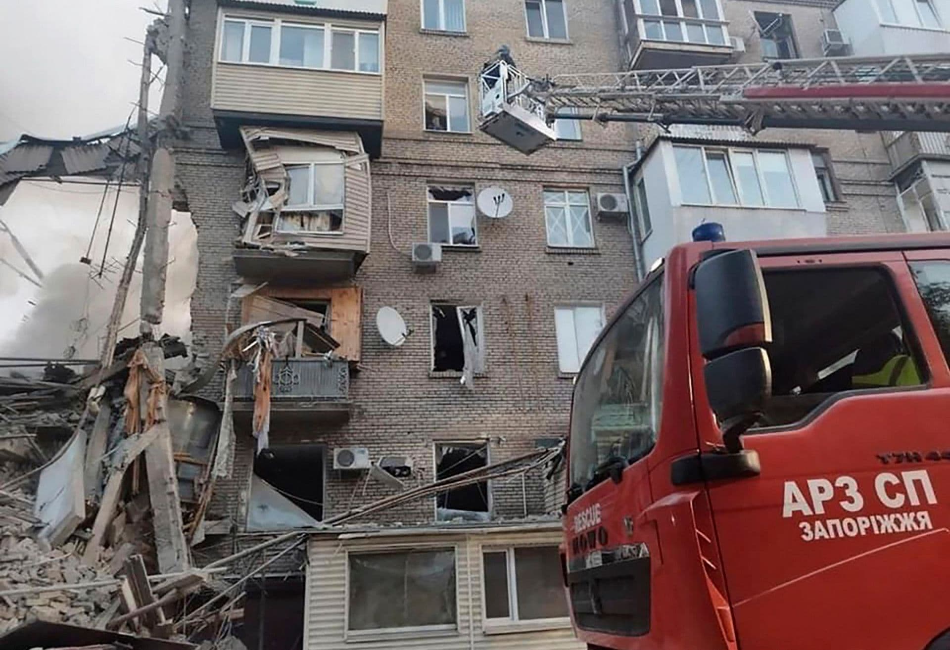 rescuers work on a scene of building damaged by shelling in Zaporizhzhia