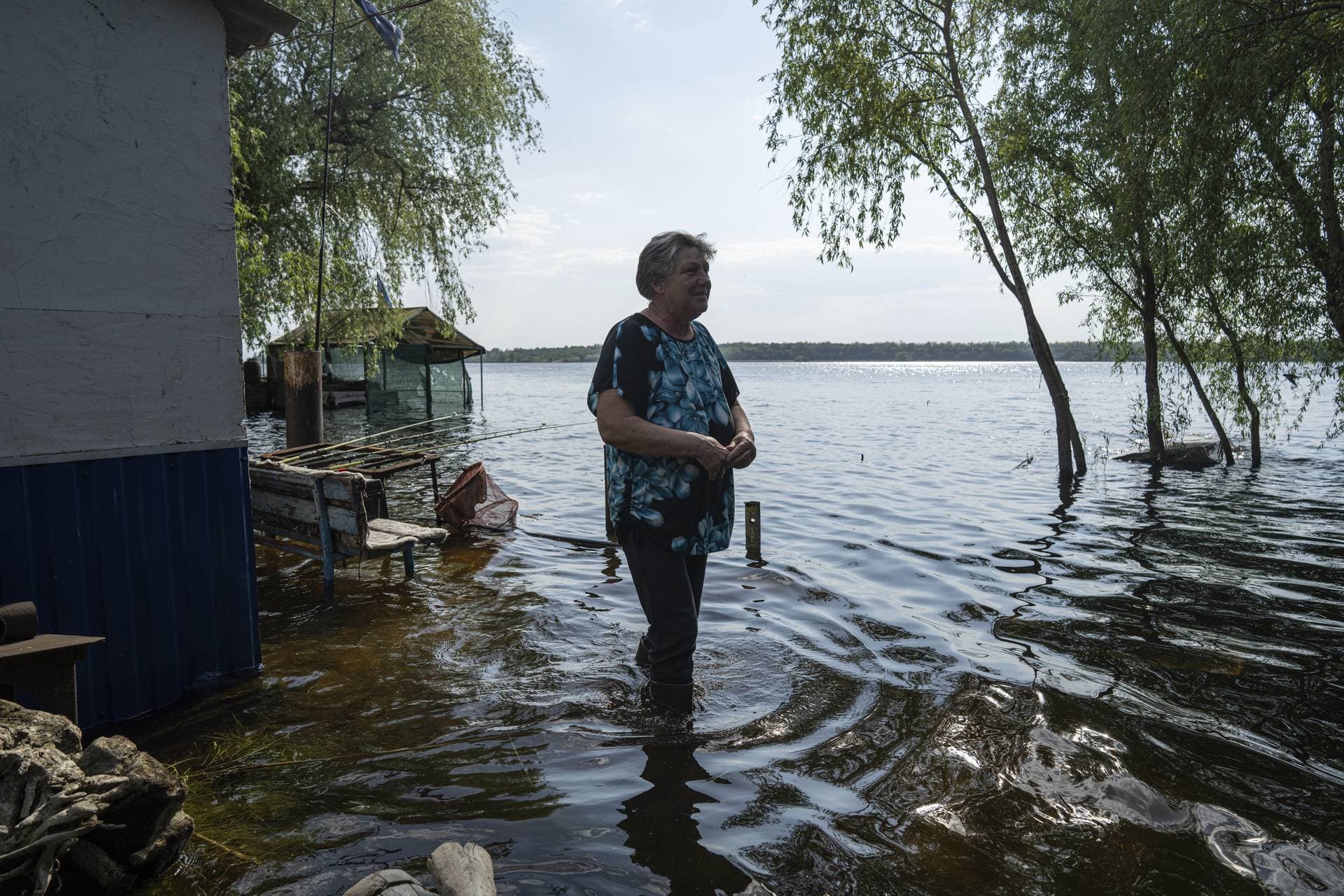 Lyudmila Kulachok stands in the flooded courtyard of her house on an island at Kakhovka Reservoir on Dnipro River