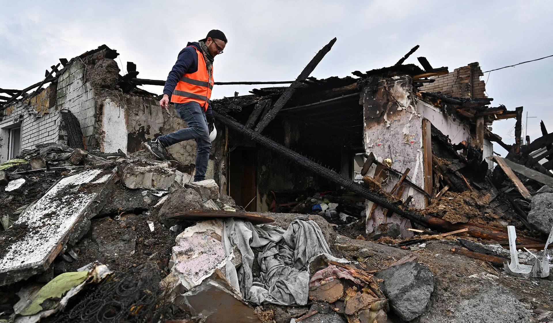 A volunteer inspects the remains of a residential house damaged by a Russian missile strike in Zaporizhzhia
