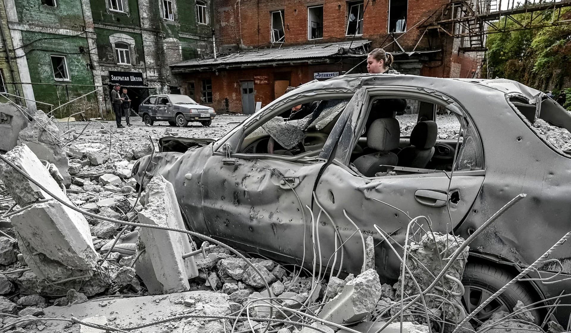 A woman stands near her destroyed car near an old mill, built around 1885, also destroyed during a Russian missile attack in Zaporizhzhia