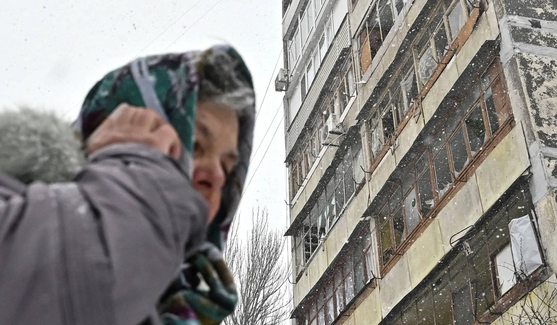 A local woman stands next to a damaged apartment building at a site of a Russian missile strike in Zaporizhzhia