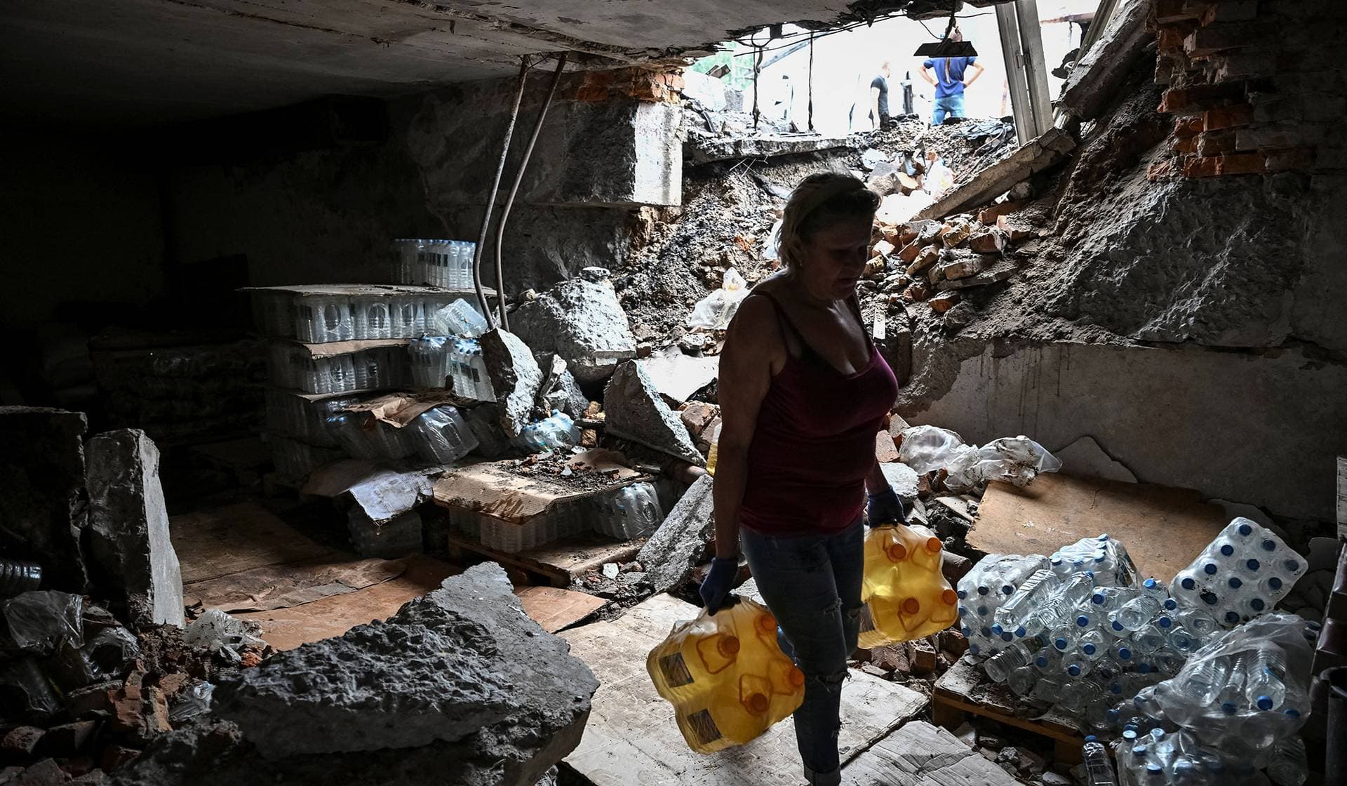 A vendor collects surviving goods at the site of a street market hit by a Russian drone in Zaporizhzhia