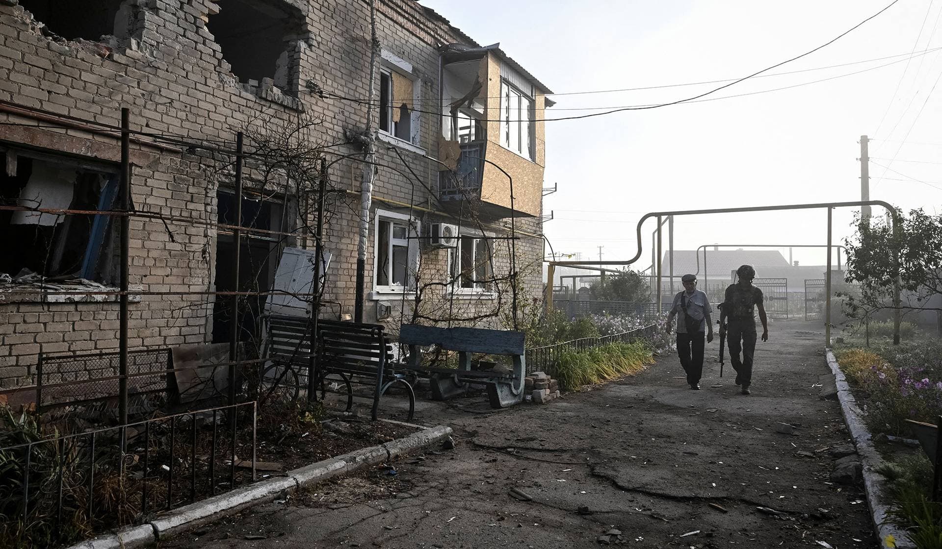 A member of the police evacuation unit assists a resident during an evacuation from the frontline village of Bilenke