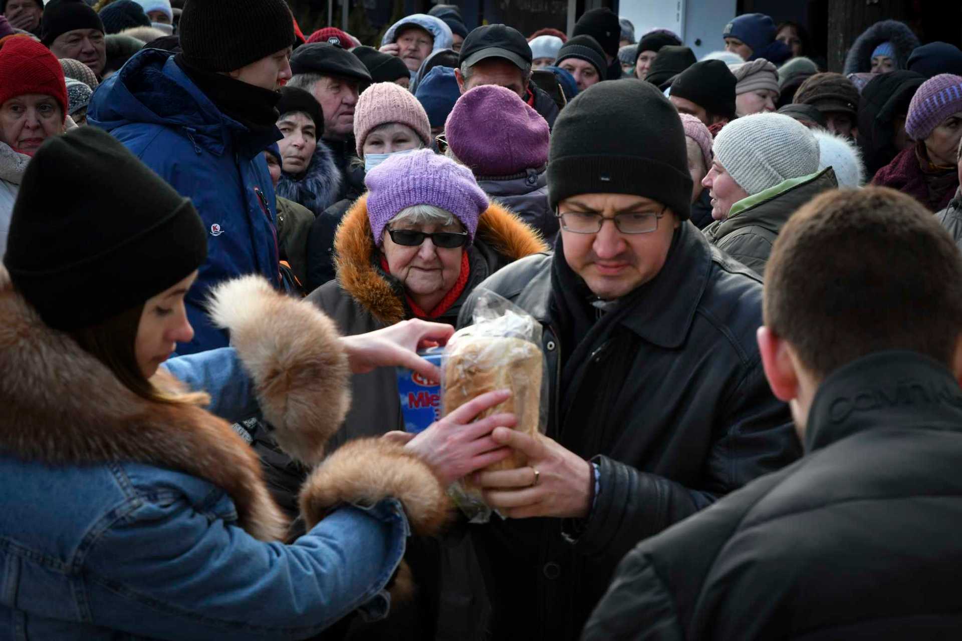 People receive bread at a humanitarian aid distribution spot in Zaporizhzhya