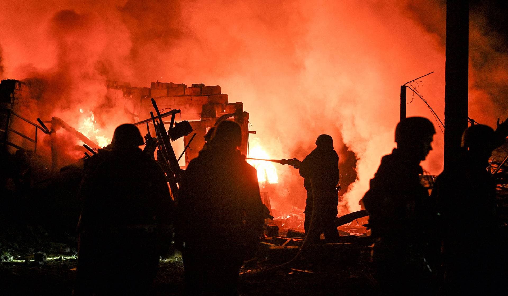 Firefighters work at the site of a car garages of residents which were hit by an overnight Russian missile strike in Zaporizhzhia