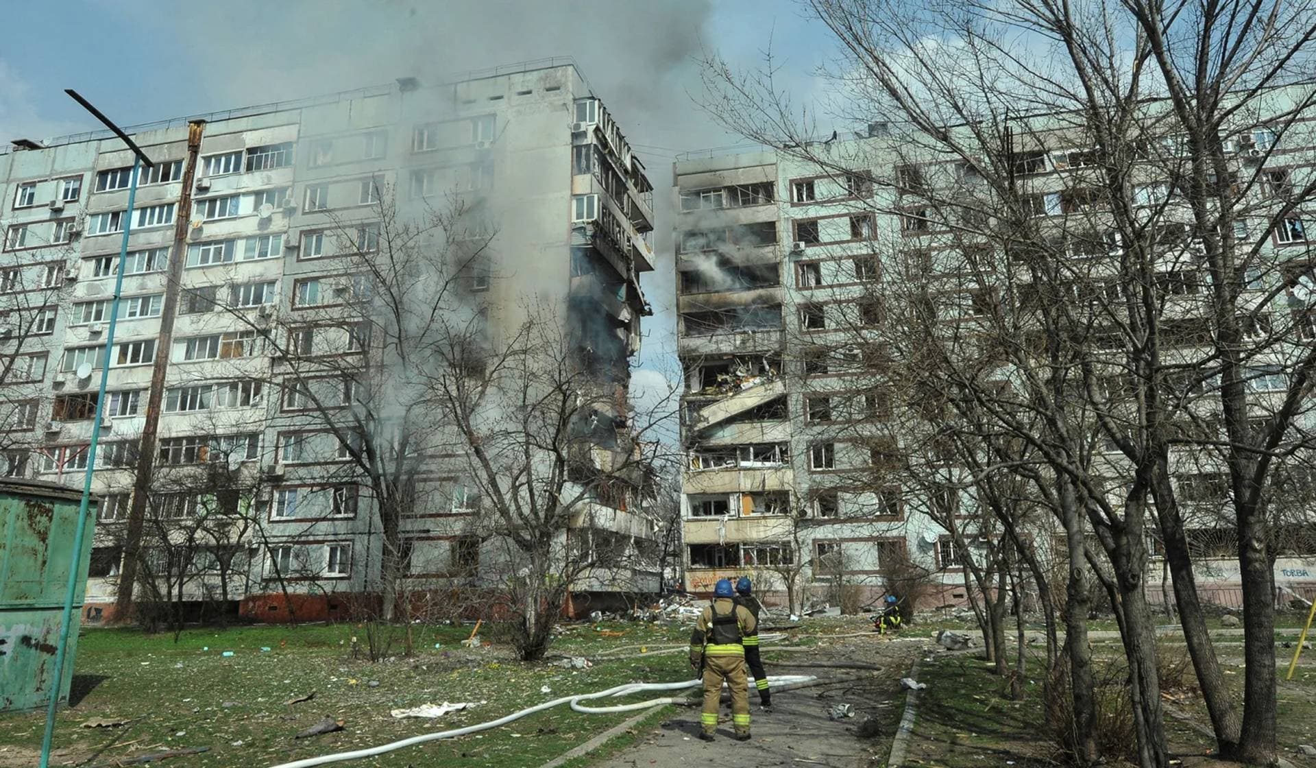 Rescuers stand in front of a residential building damaged by a Russian missile strike in Zaporizhzhia