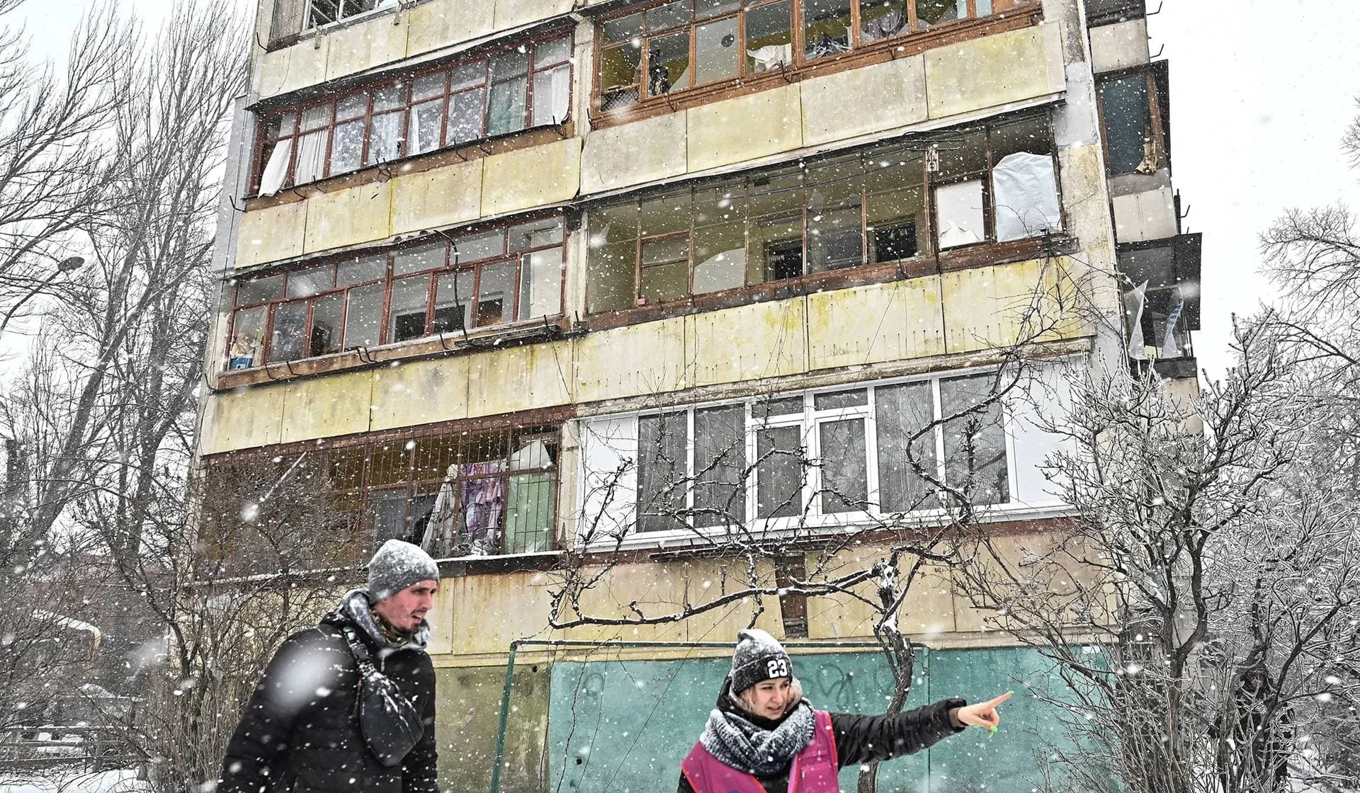Volunteers talk next to a damaged apartment building at a site of a Russian missile strike in Zaporizhzhia