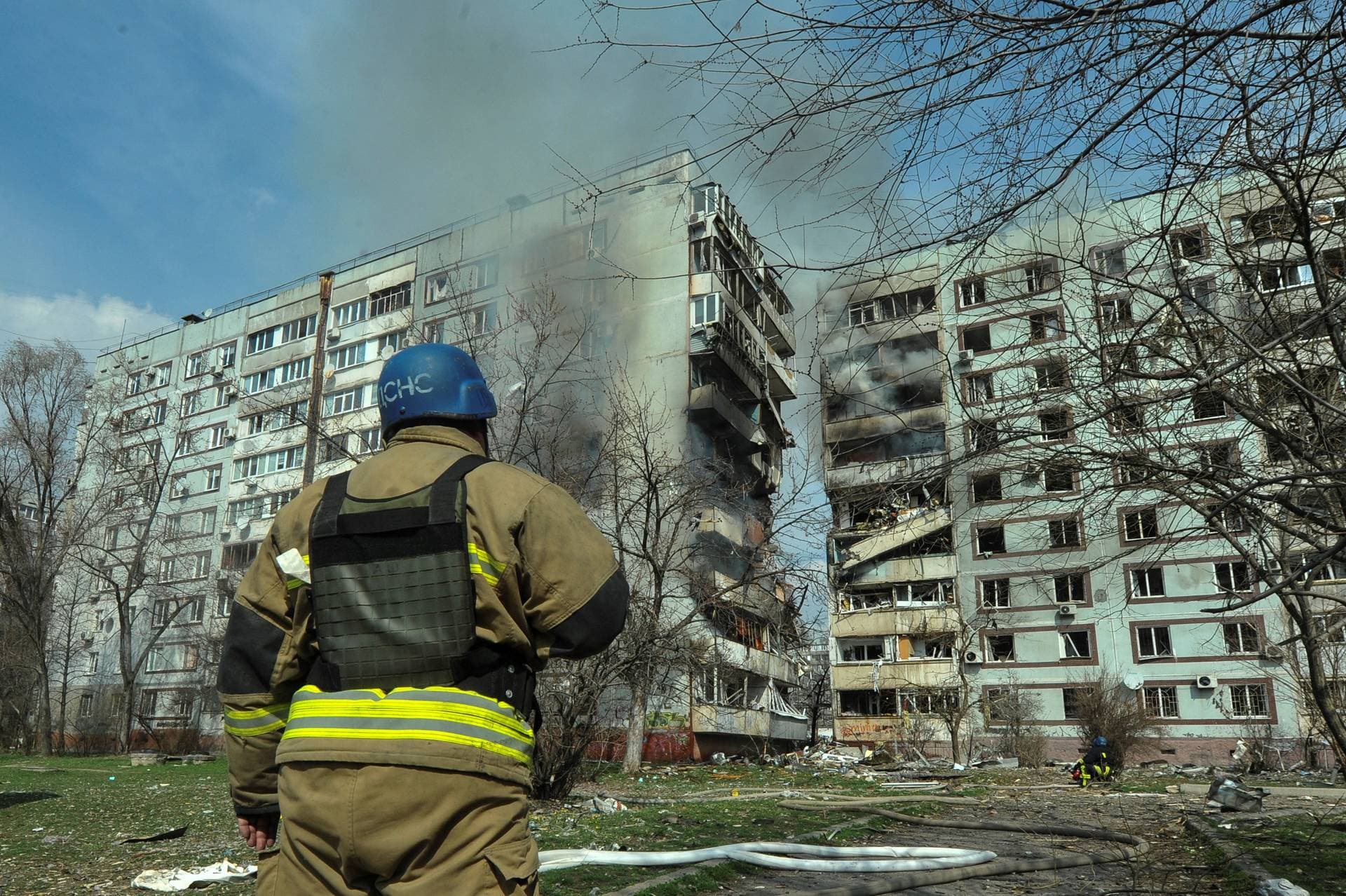 A rescue worker stands in front of a residential building damaged by a Russian missile strike in Zaporizhzhia