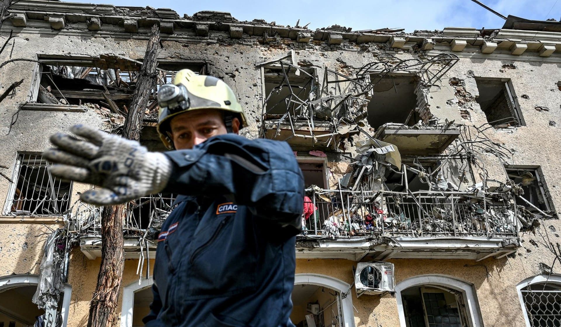 A rescuer gestures in a front of a residential building damaged by a Russian missile strike in Zaporizhzhia
