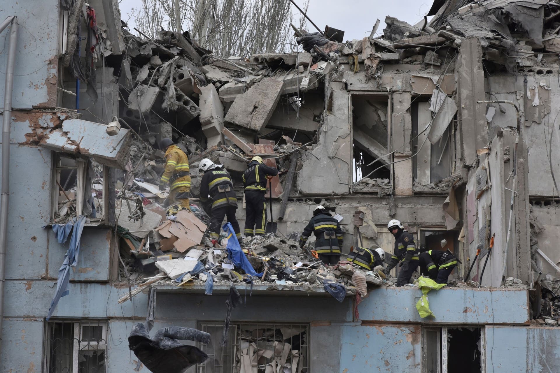 Ukrainian State Emergency Service firefighters inspect a damaged house after Russian shelling hit in Zaporizhzhia