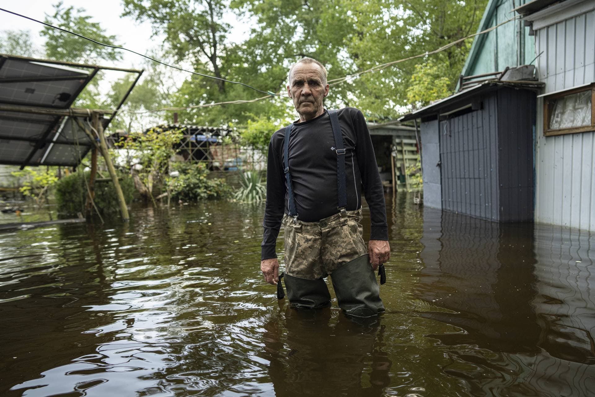 Ihor Medyunov stands in the flooded courtyard of his house on an island at Kakhovka Reservoir on Dnipro River