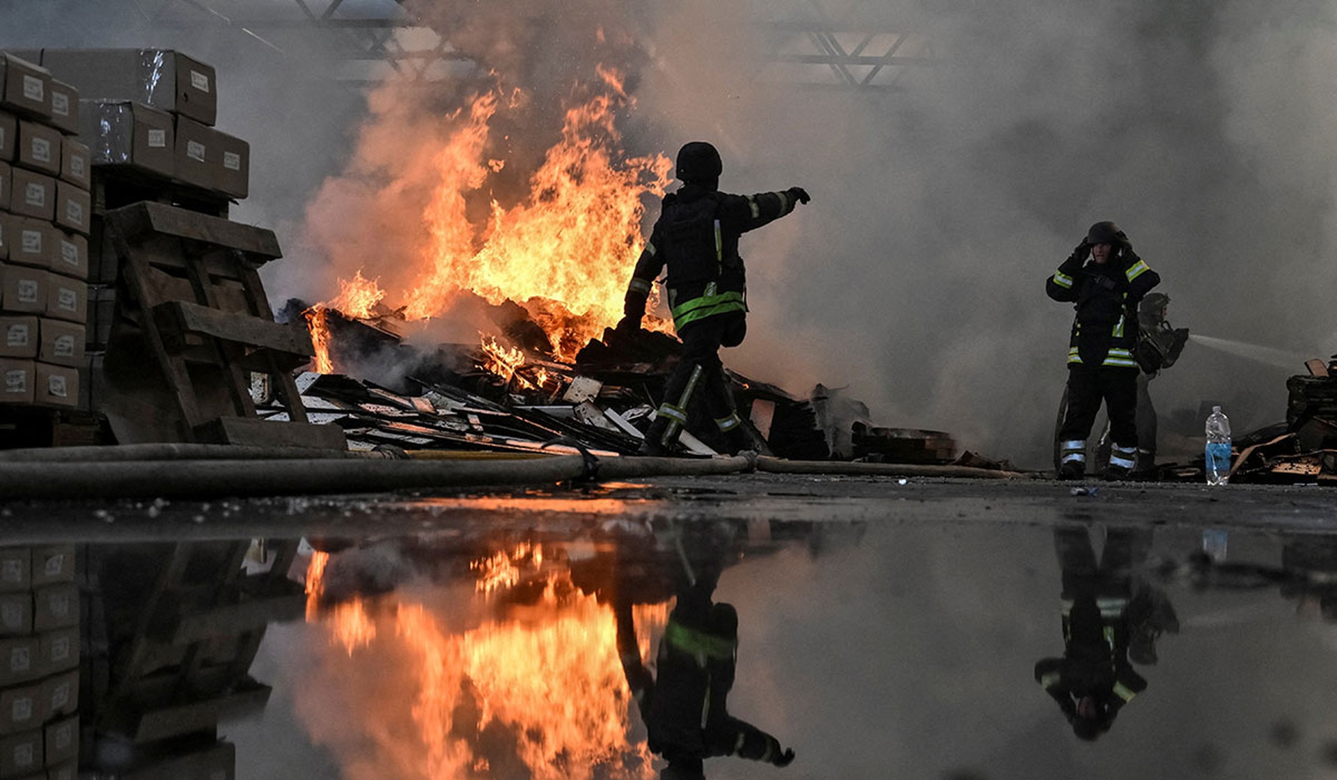 Firefighters work at the site of a furniture warehouse hit by a Russian drone strike in Zaporizhzhia