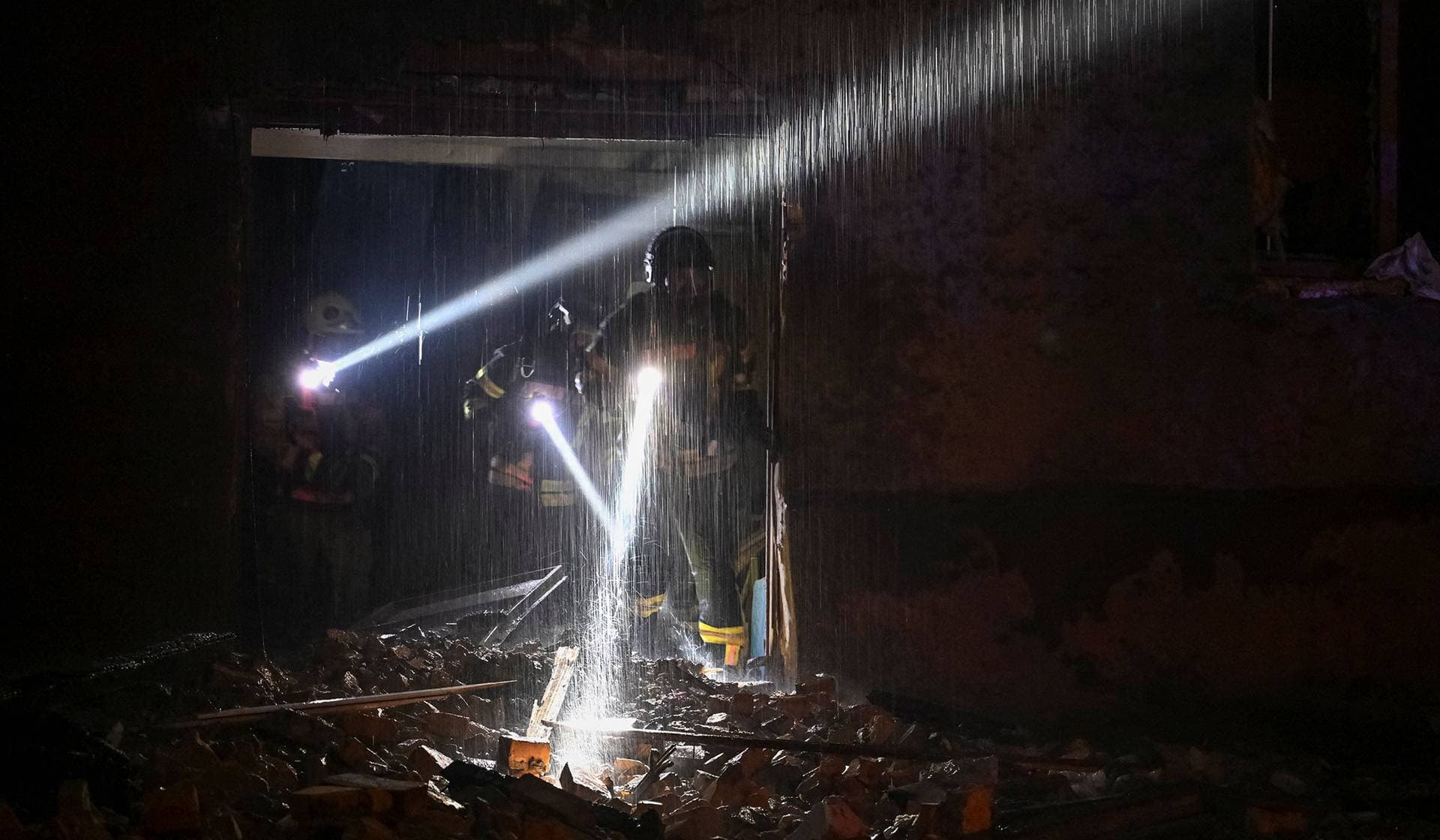Firefighters work at the site of an apartment building hit by a Russian drone strike in Zaporizhzhia
