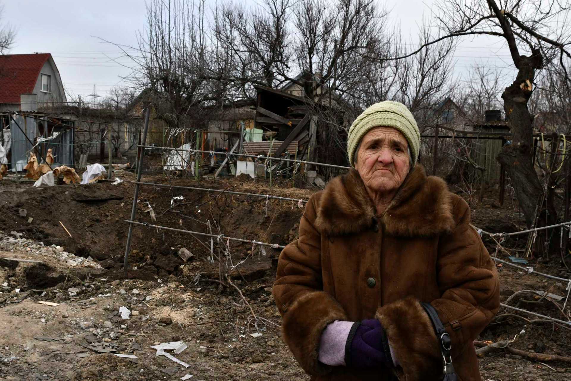 Tamara Makshanova 75, stands near a crater left by the Russian rocket that damaged her home in Zaporizhzhya