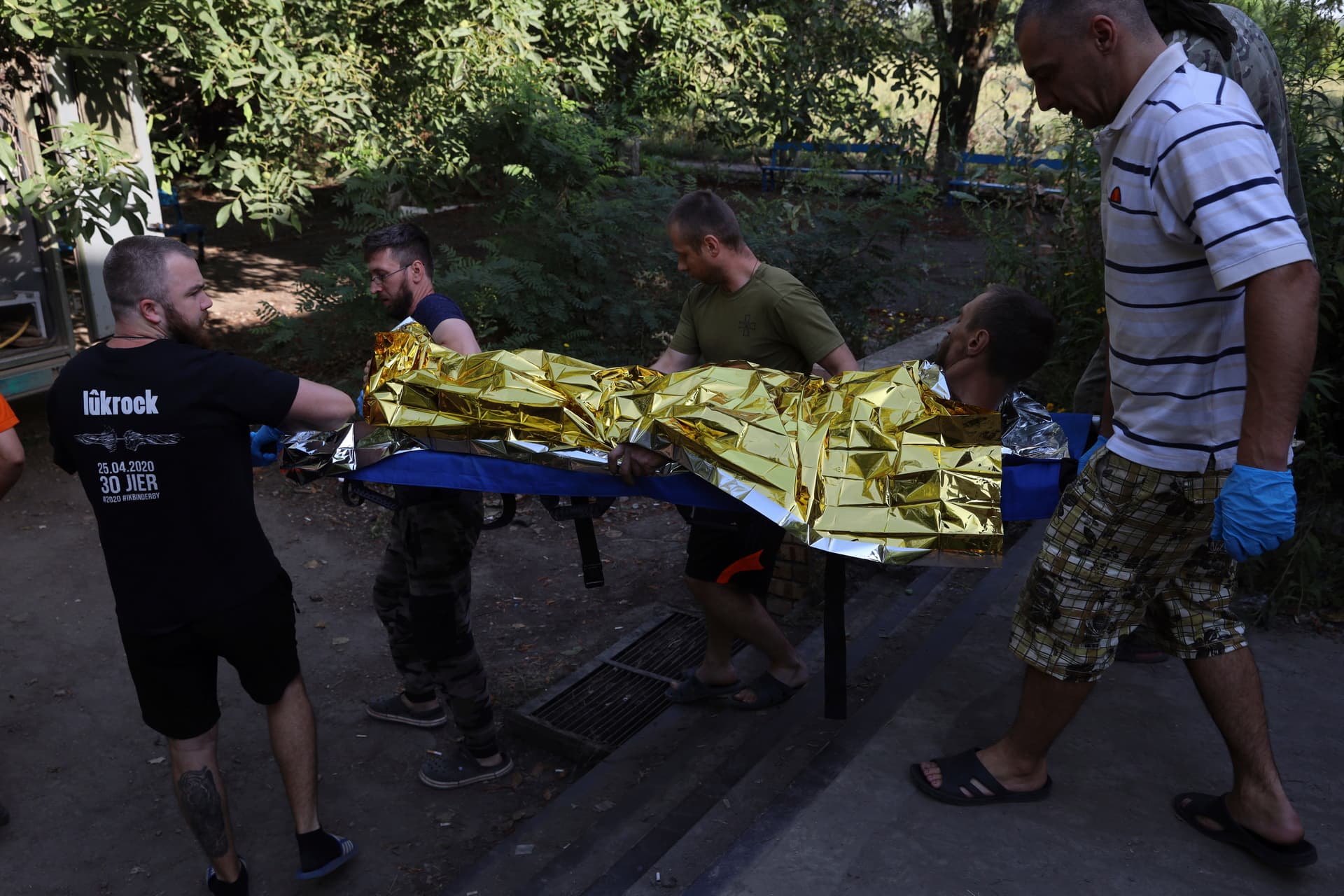 People carry an injured Ukrainian serviceman in a frontline medical stabilization point in Zaporizhzhia region