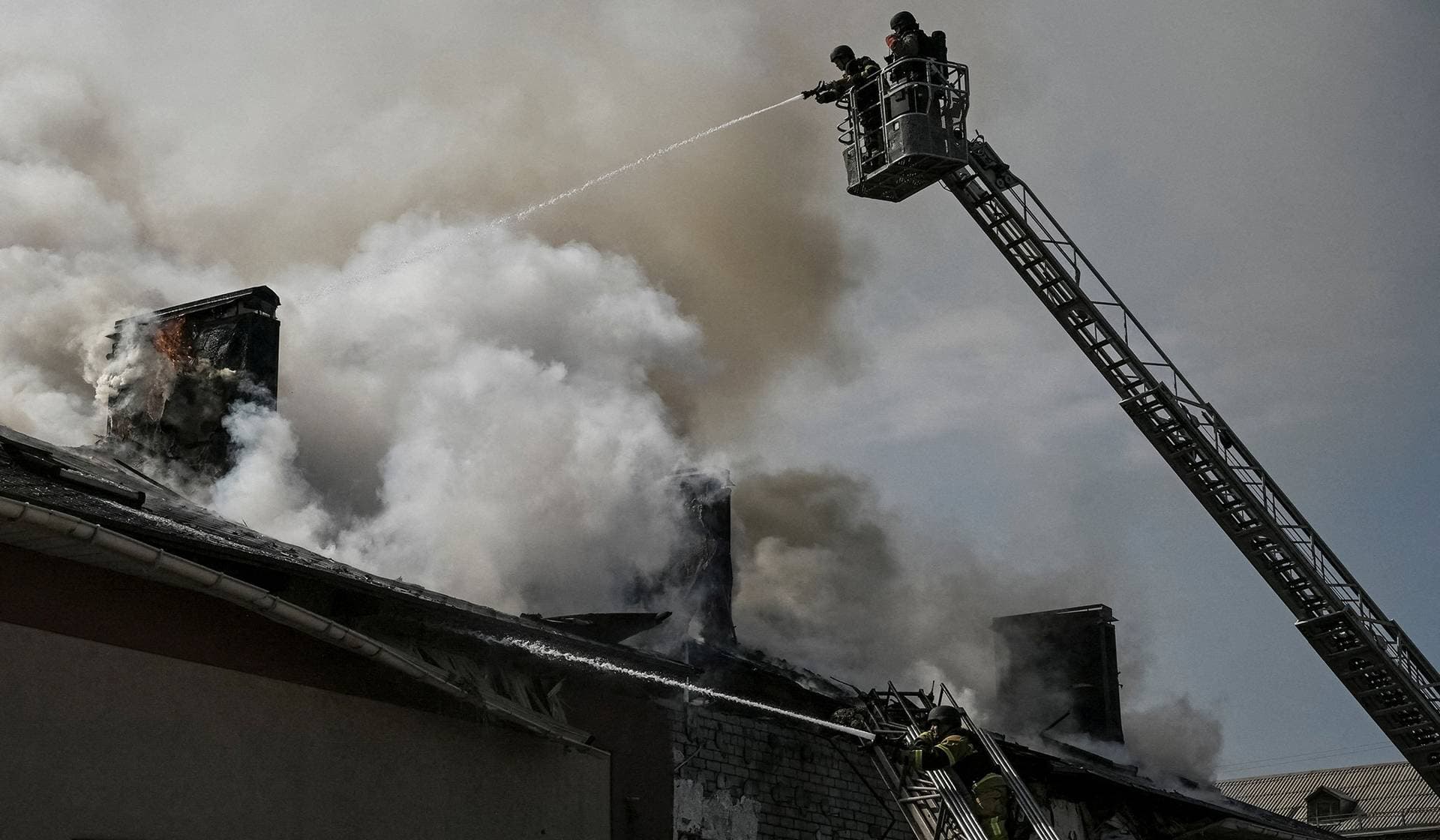 Firefighters work at the site of a building hit by a Russian drone strike in Zaporizhzhia