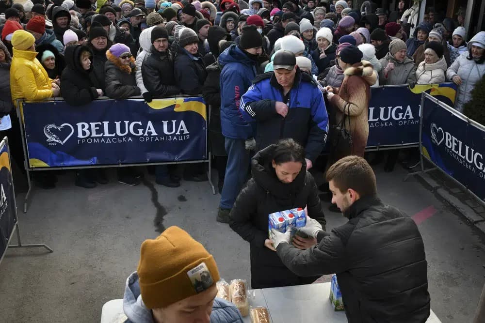 People receive bread and milk as a humanitarian aid at a distribution spot in Zaporizhzhya