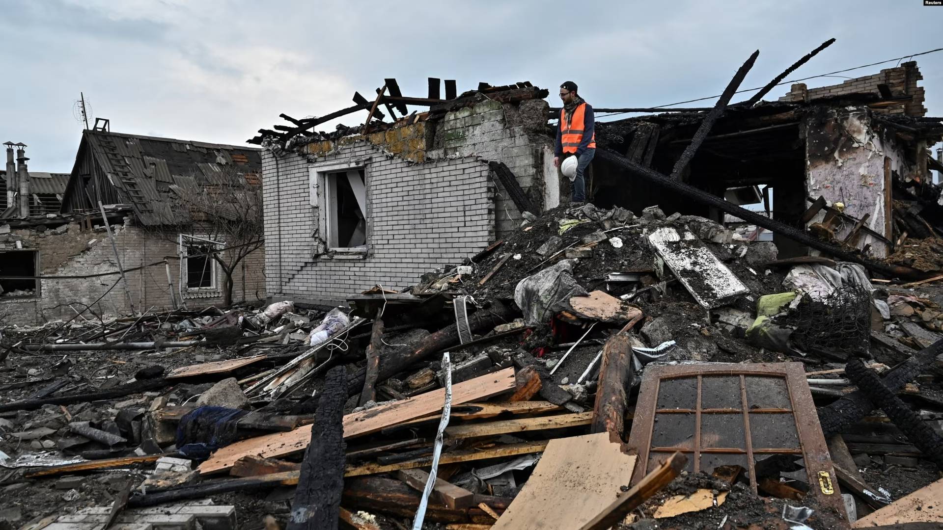A volunteer inspects the aftermath of a Russian missile strike overnight on a residential area in Zaporizhzhya