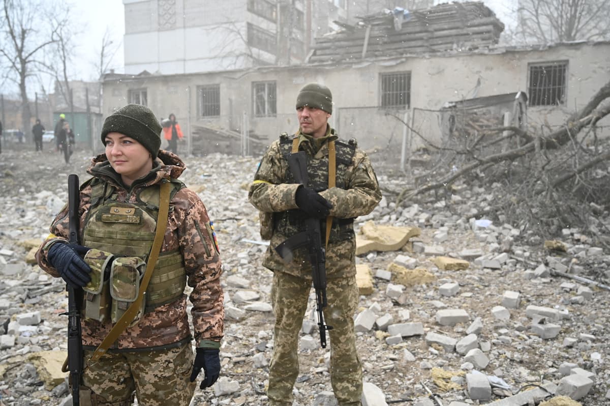 Ukrainian soldiers stand near a school building destroyed by shelling in Zhytomyr