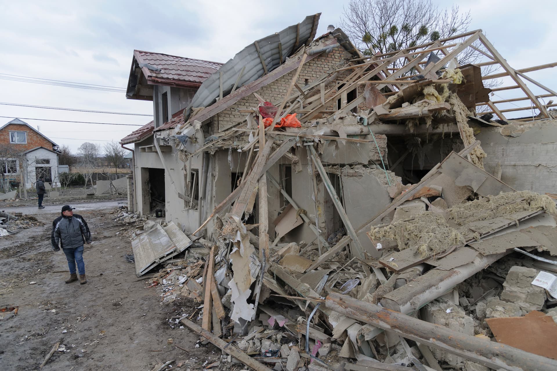Villagers clear the rubble after Russia's night rocket attack ruined private houses in a village, in Zolochevsky district